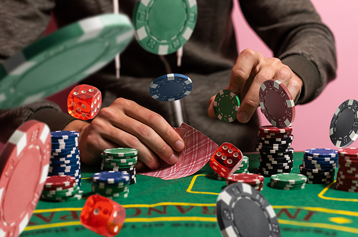 Gambler,Man,Hands,Pushing,Large,Stack,Of,Colored,Poker,Chips